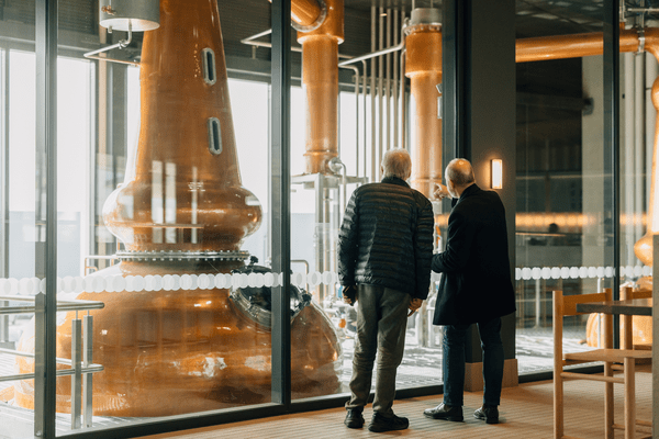 2 gentlemen viewing a copper still