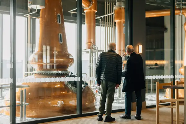 2 gentlemen viewing a copper still