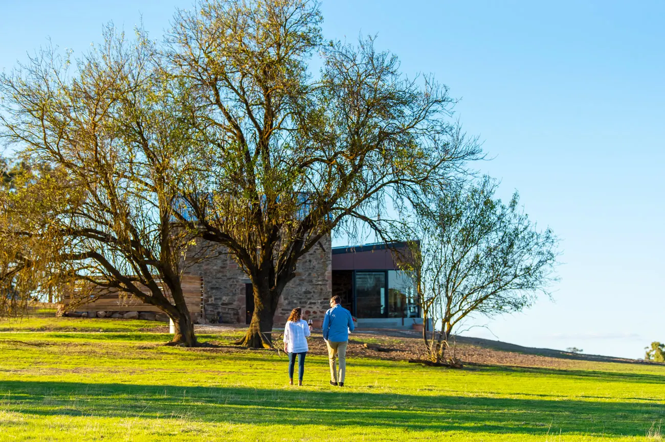 Two guests drinking wine outside of Hutton Vale Farm’s JHA Stone Cellar